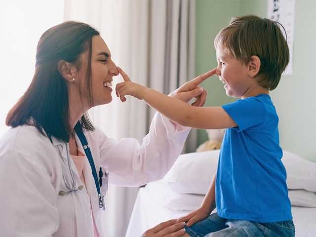 Healthcare provider and young child touching noses.