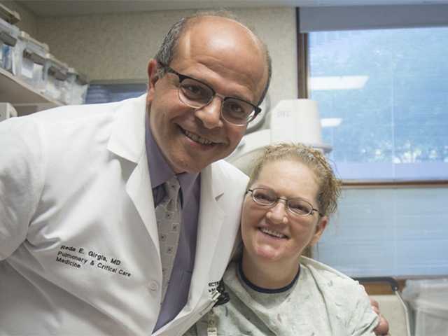Medical provider side hugging patient and smiling for photograph.