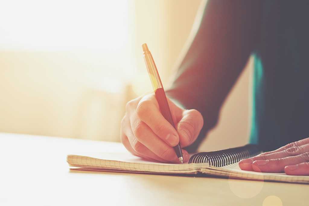Person writing in notebook.