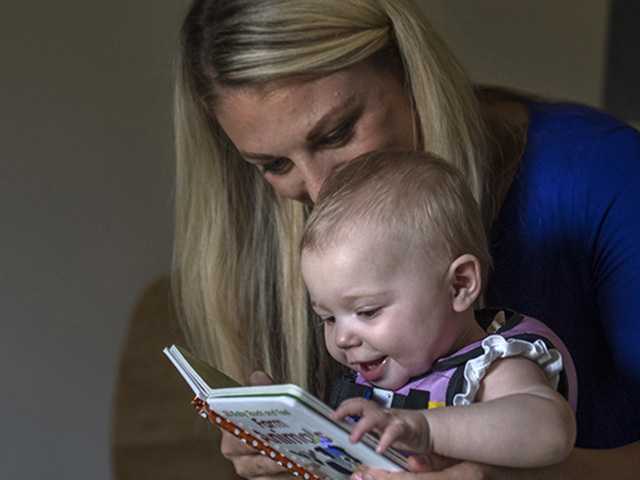 woman with baby reading book