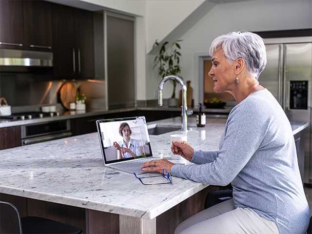 Woman talking to healthcare provider on tablet.