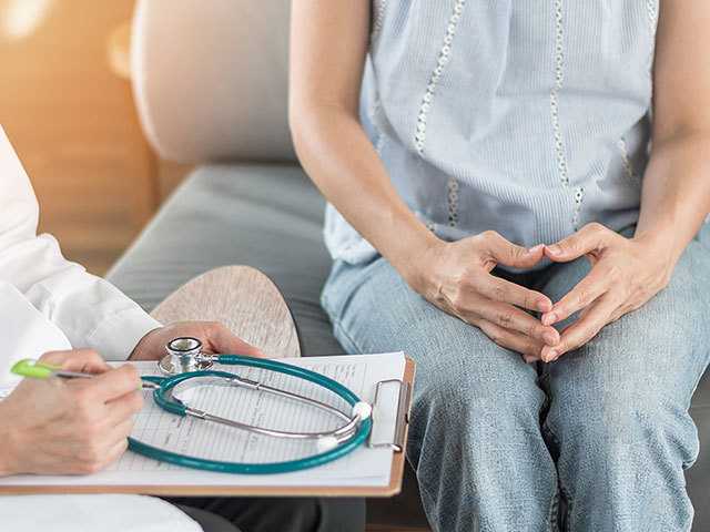 woman from waist down sitting on chair next to a doctor