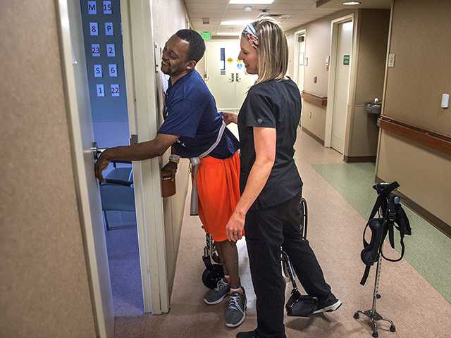 Patient receiving assistance to get out of his chair