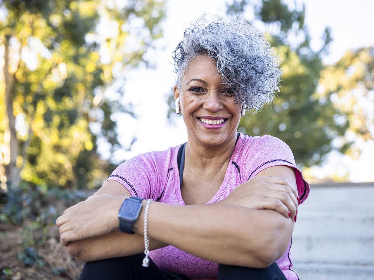 Woman with grey hair sitting outside.