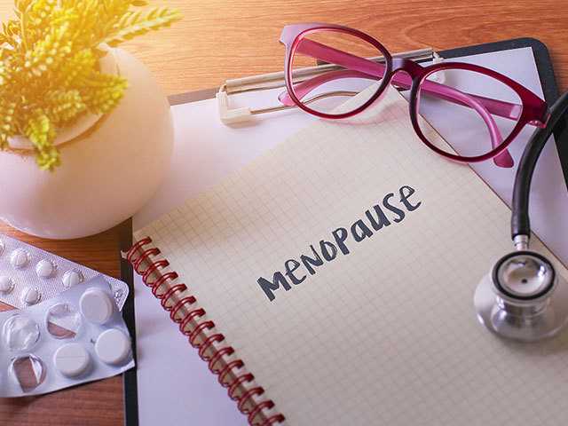 notebook sitting on a table with menopause written on the page