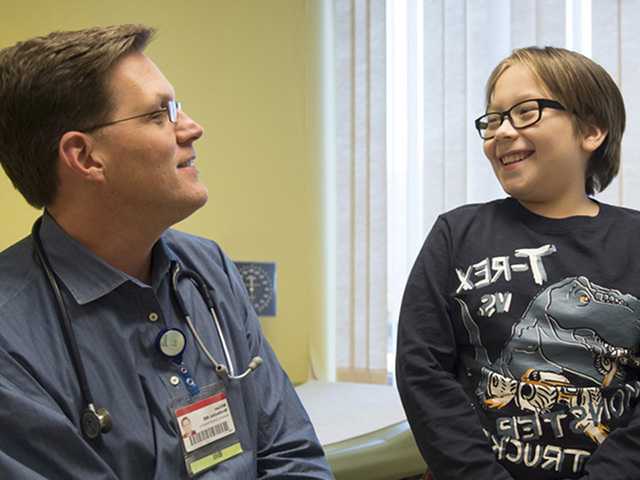 Healthcare provider talking with young boy.