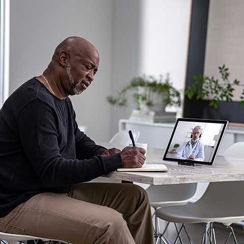 Man sitting at desk in front of laptop.