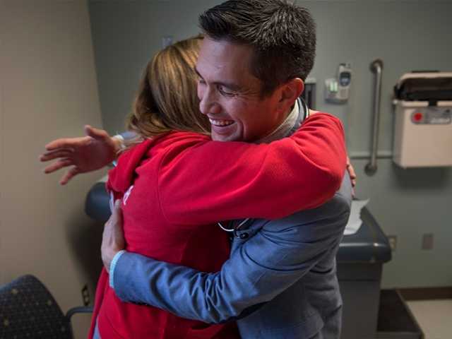 Health care provider hugging woman.