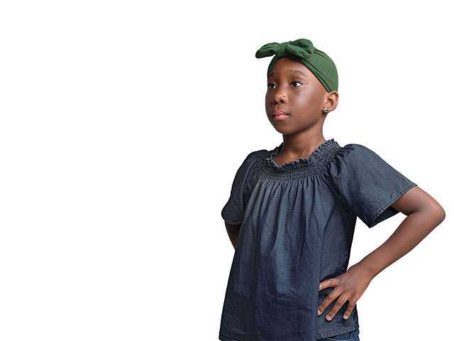 Young girl with hands on hips, looking serious.
