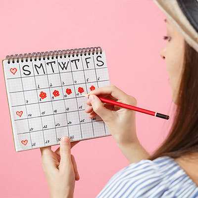 Woman marking days on calendar