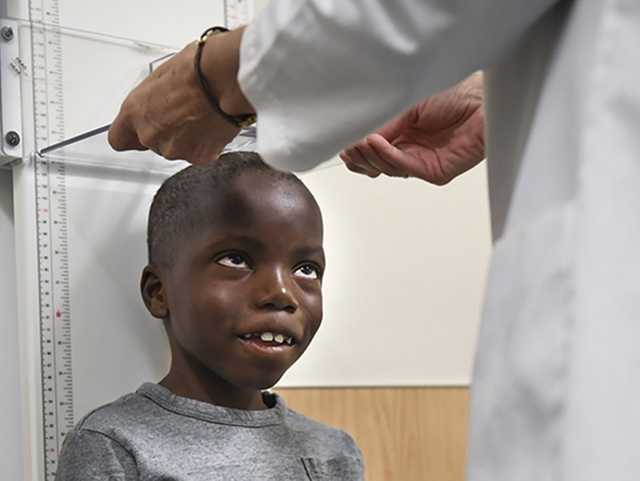Young boy getting height measured.