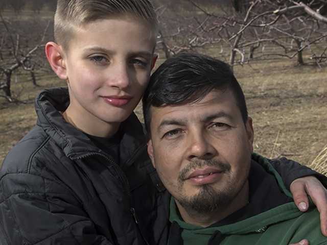 Man and boy outside surrounded by trees without leaves.