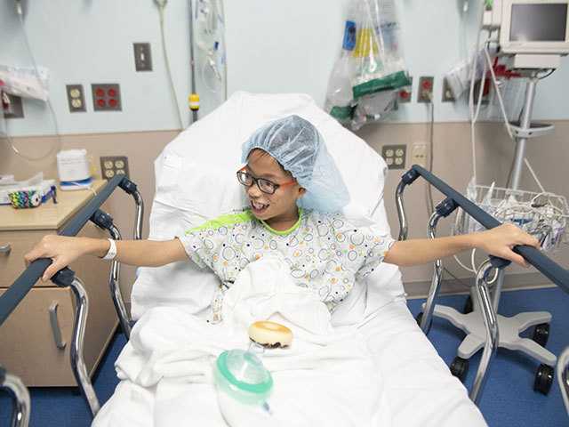 Child with food in hospital bed.