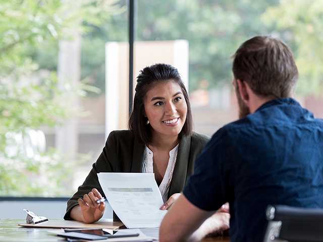 Woman discussing paperwork with man.