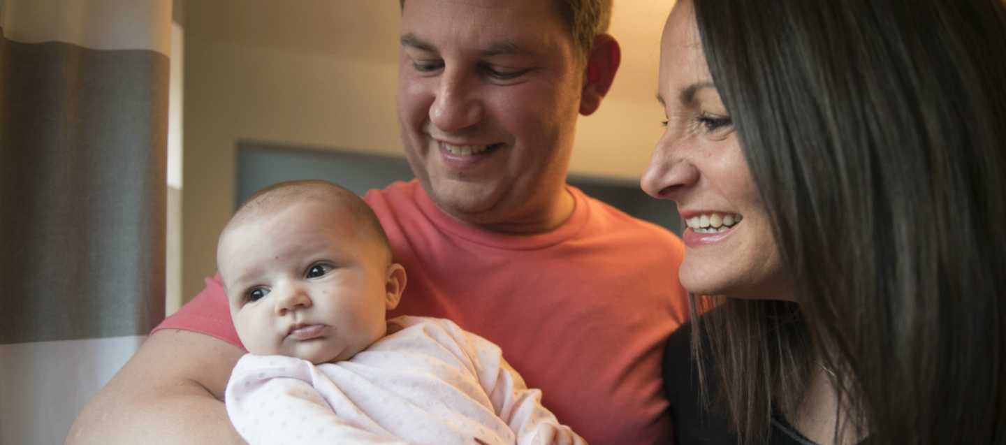 Family happily embracing their baby