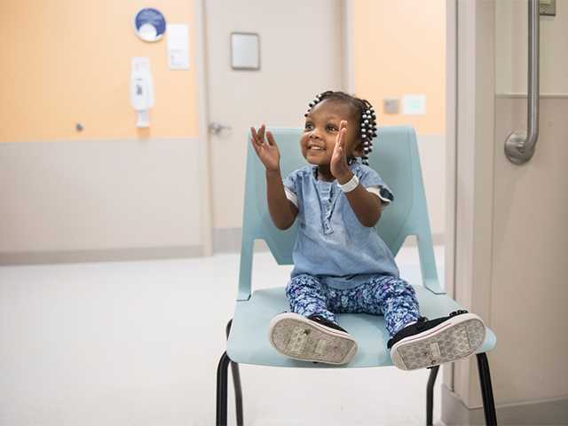 child in exam chair clapping