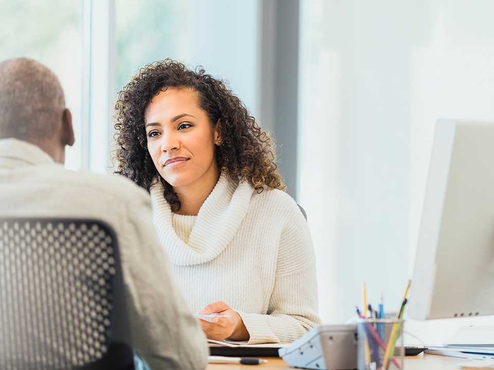 Woman talking to man across table.