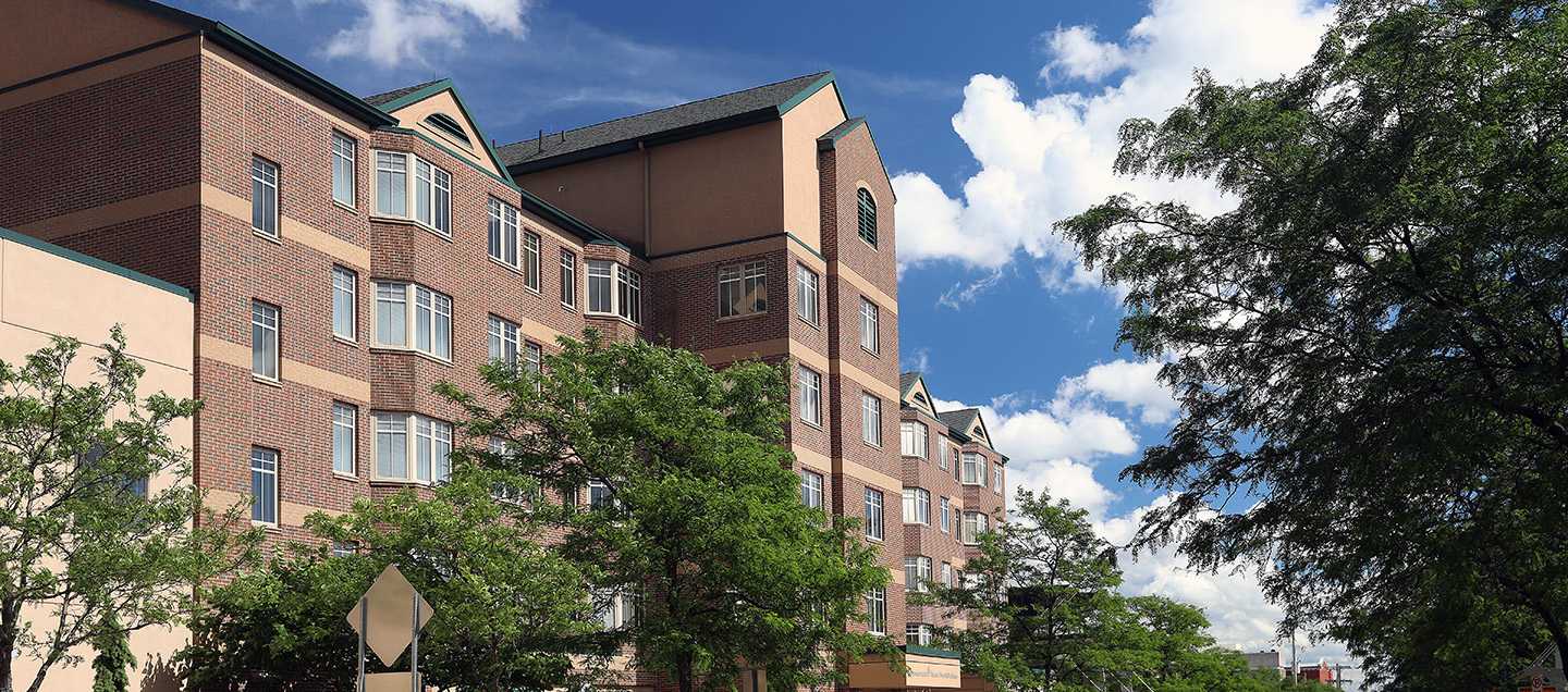 brick multi-story building with trees surrounding it