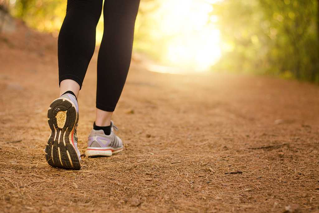 Photo of bottom half of person, walking on trail.