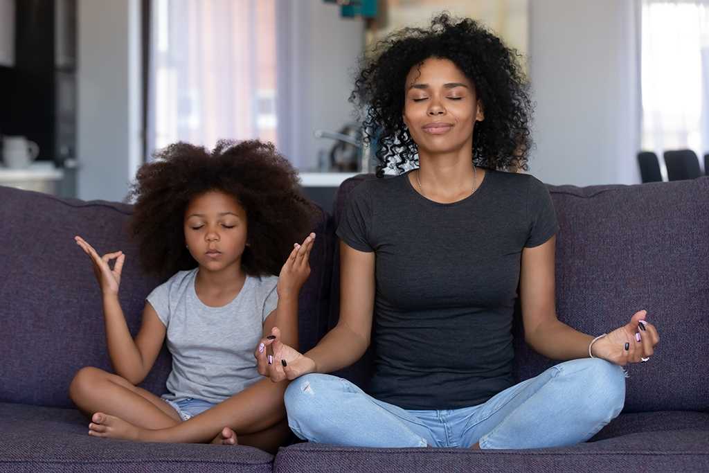 Mother and daughter meditating.
