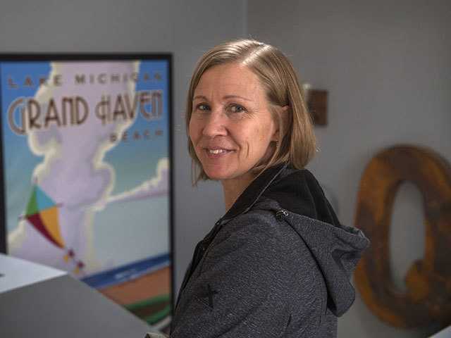 woman with shoulder length blonde hair looking over her shoulder and smiling