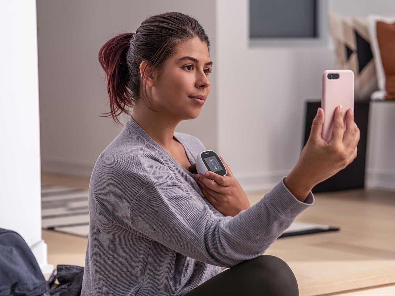 Woman taking diagnostic test with device.