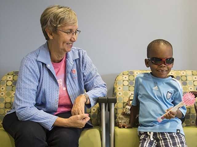 Young child and caregiver smile while waiting in the waiting room