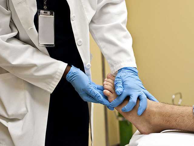 Healthcare provider examining patients foot.