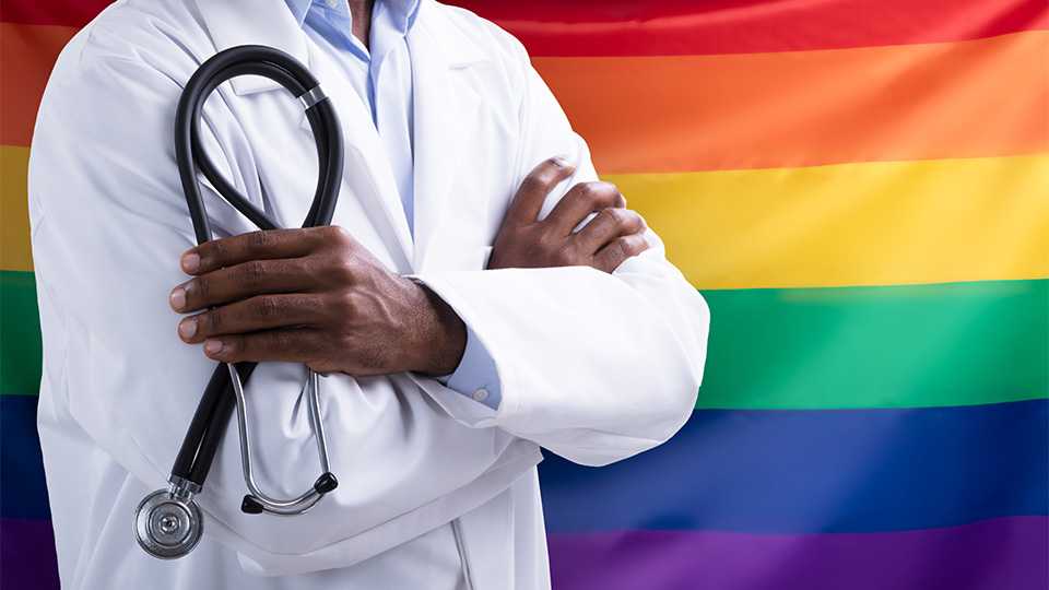 Health care provider standing in front of flag.